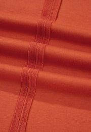 Orange-red blouse with balloon sleeves and patchwork detail.
