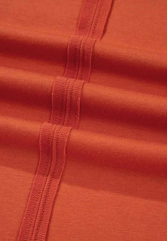 Orange-red blouse with balloon sleeves and patchwork detail.