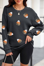 Black ribbed knit top with allover candy corn sequin embellishments.