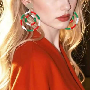 Festive beaded hoop earrings in red, white, and green, with a spiral design.