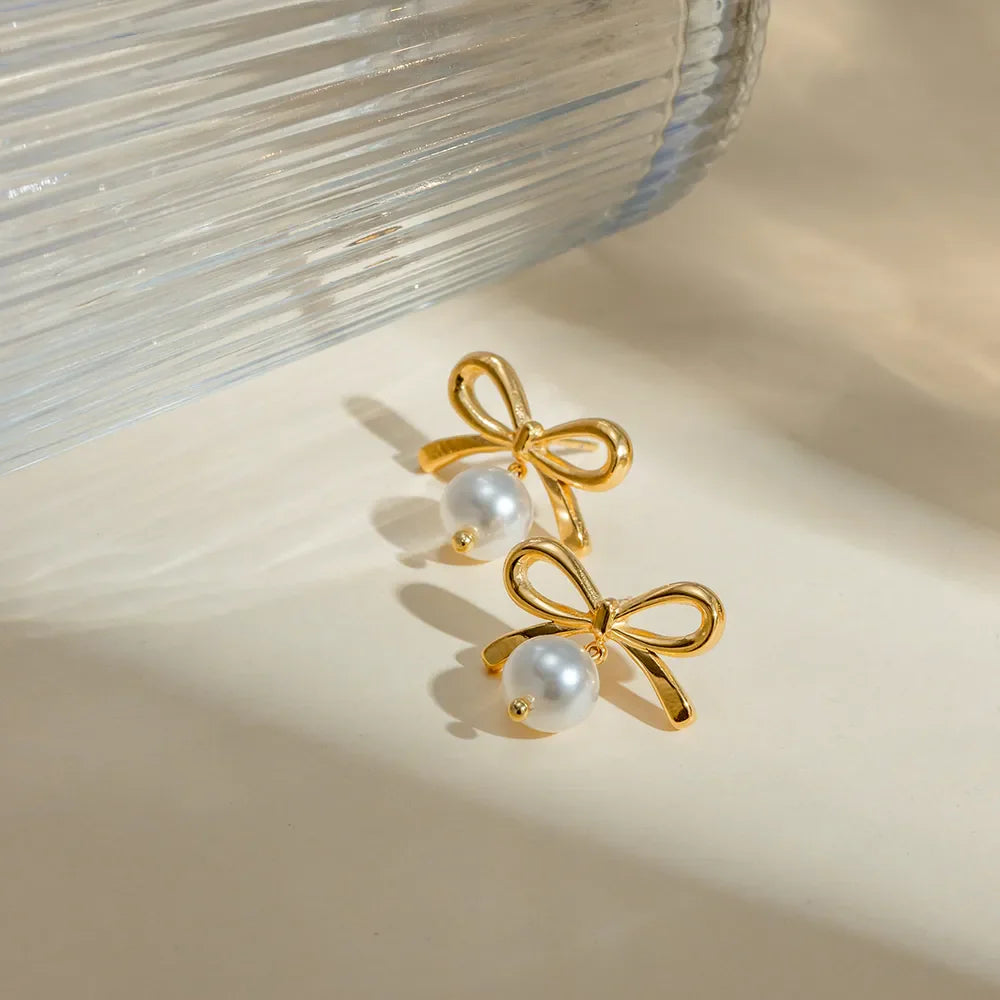 Gold bow drop earrings with pearl accents