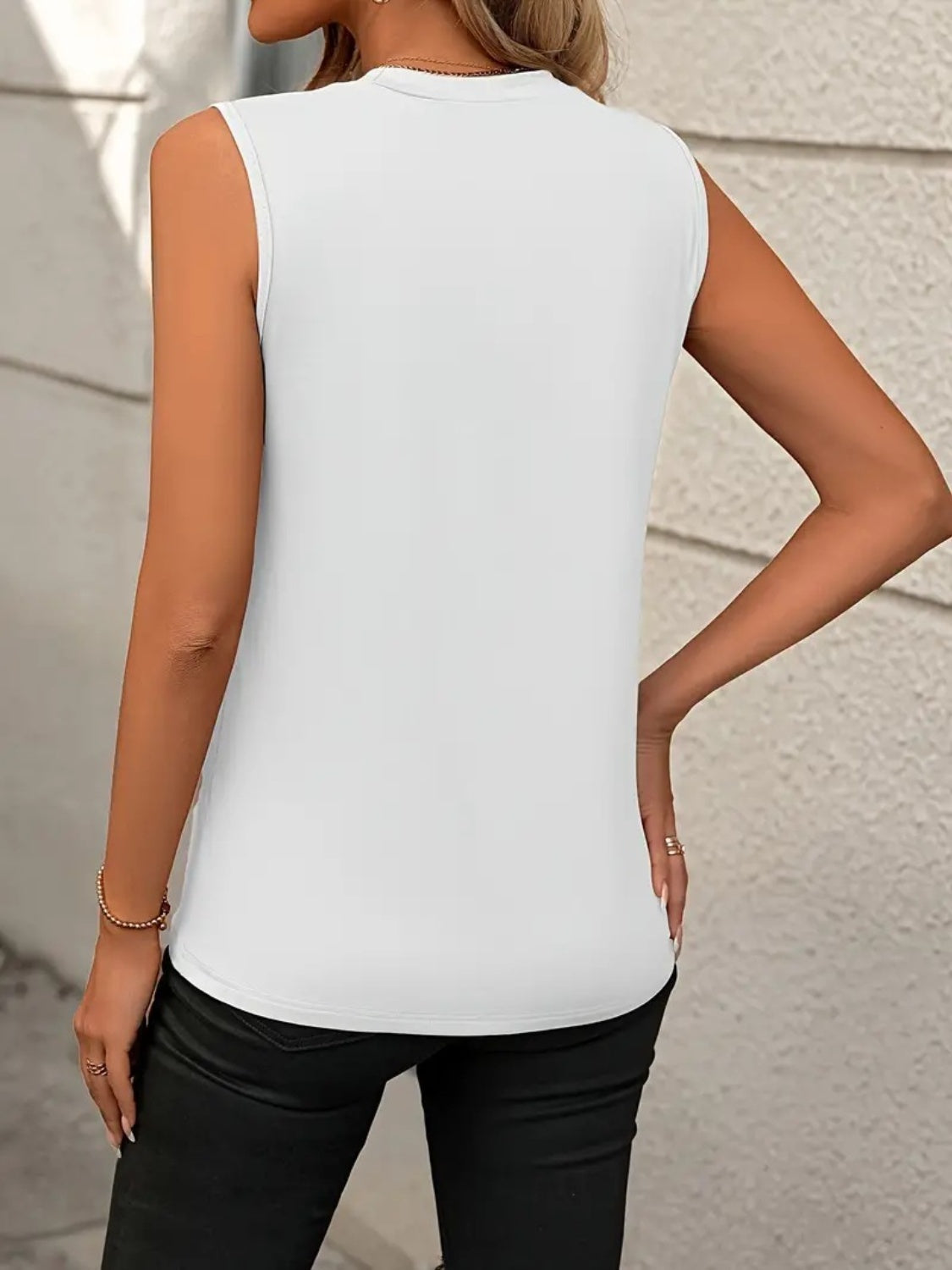 White sleeveless top with diagonal seam detail and crew neck.