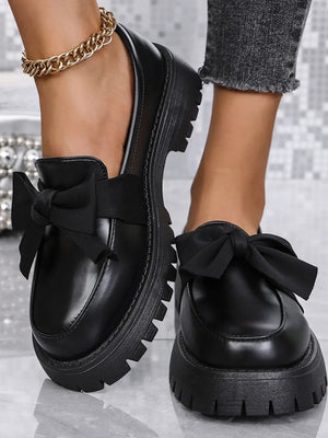 Black matte platform bow loafers with chunky lug sole.
