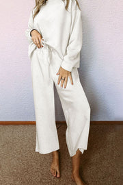 White loungewear set with textured geometric pattern, crew neck, drop sleeves, and wide-leg pants with drawstring waist.