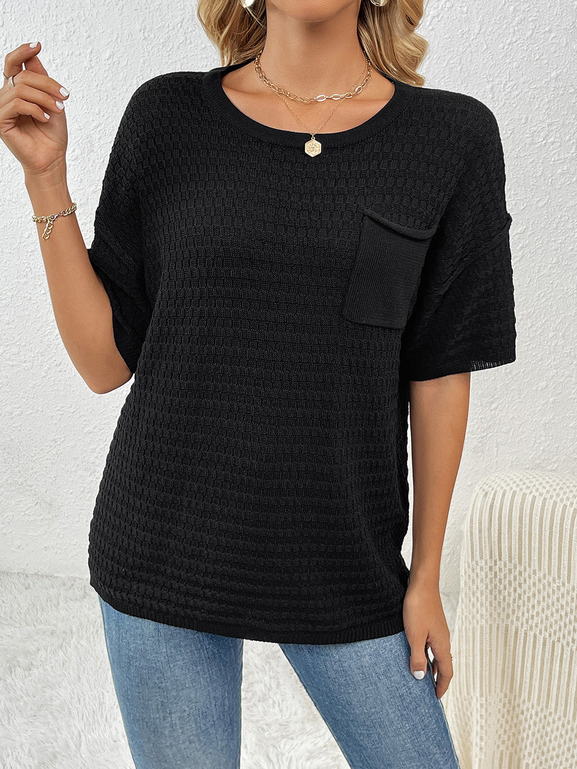 Black textured knit t-shirt with boxy silhouette and chest pocket.