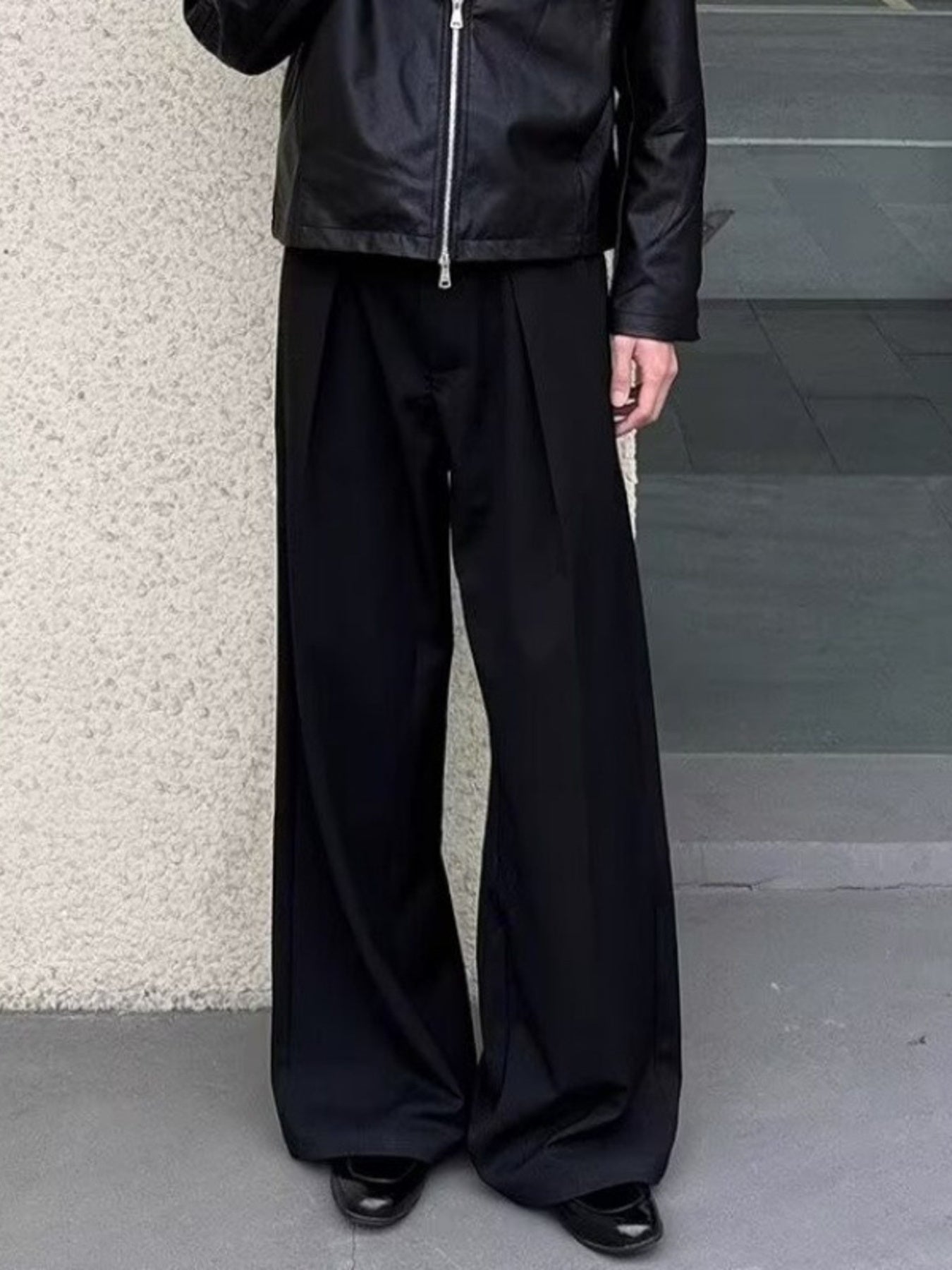 Men's black wide-leg sweatpants with pleats and a relaxed fit.