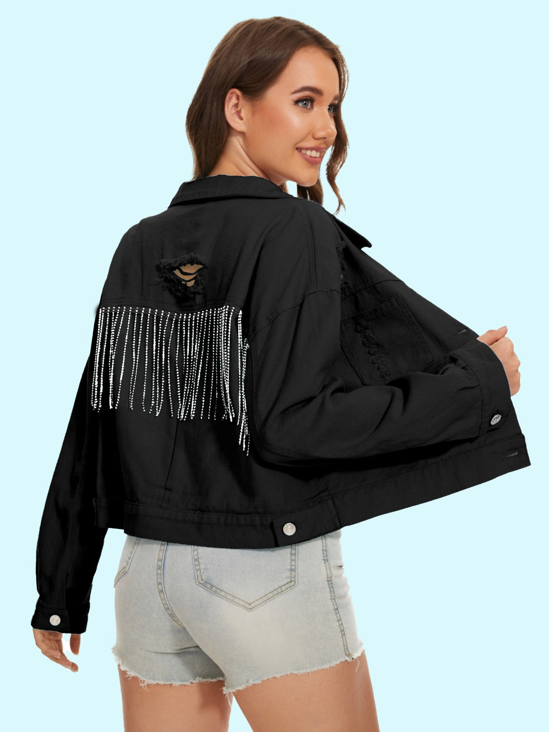 Black distressed denim trucker jacket with crystal fringe detail and ripped back.