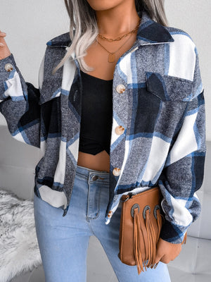 Oversized blue tartan shacket with patch pockets and button front, worn open over a black crop top.