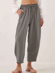 Gray balloon trousers with drawstring waist and sculpted seamline detail.