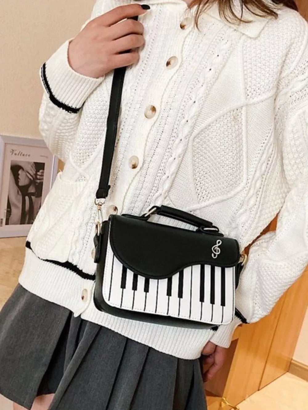 Black and white piano key crossbody bag with a treble clef detail.