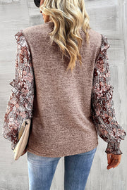 Knit top in dark gray with floral chiffon sleeves and ruffled details.