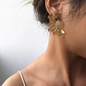 Textured gold flower stud earrings with detailed petals and center.