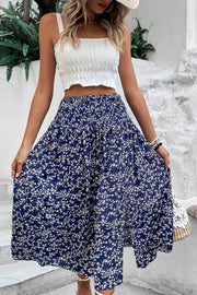 Ditsy floral midi skirt with slit in navy blue, featuring a smocked waistband and flowy silhouette.
