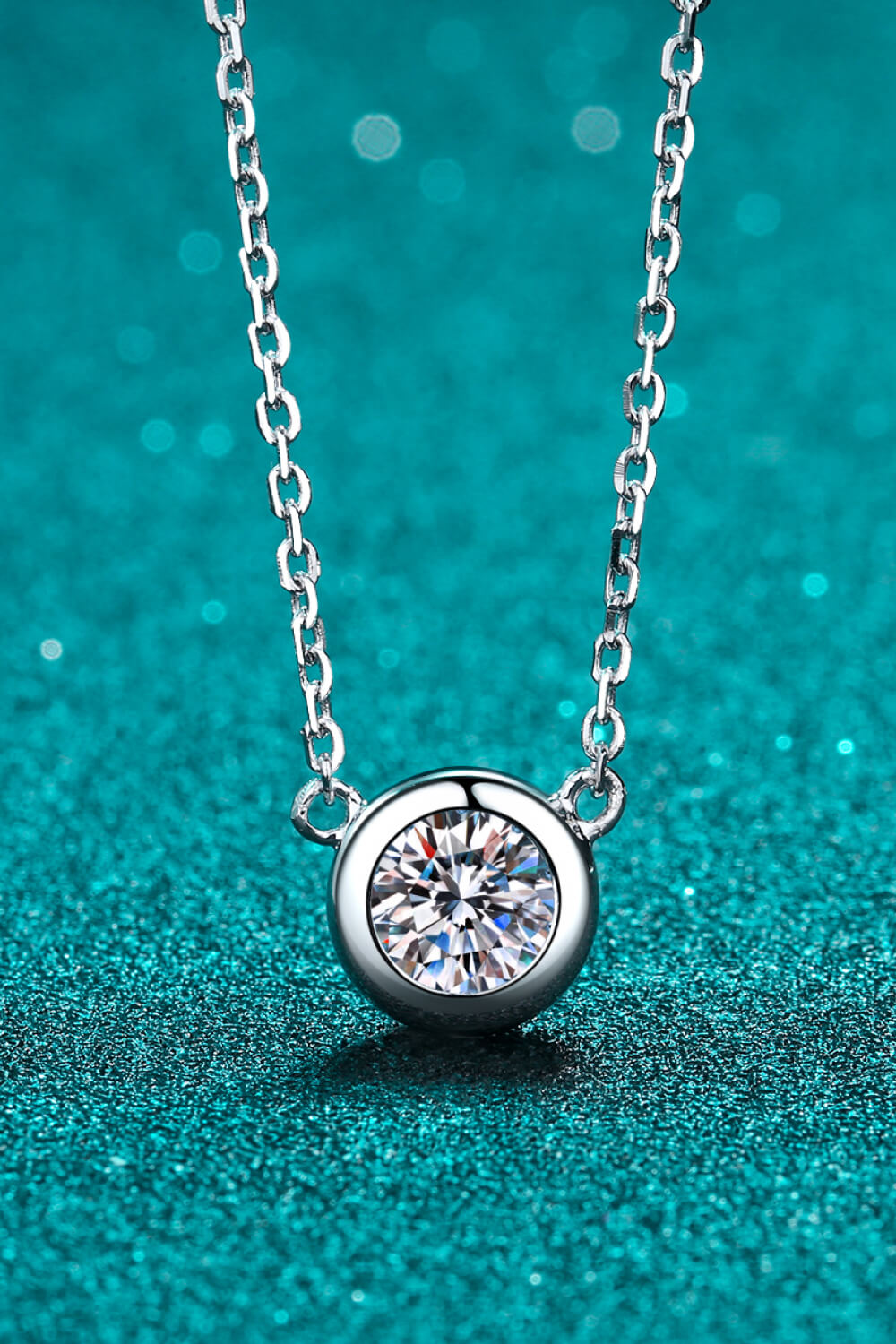 Solitaire bezel-set diamond necklace in silver with a delicate chain.