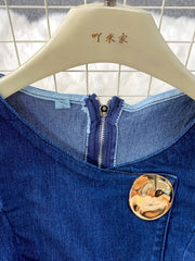 Dark blue cotton denim vest with asymmetrical button detail and silver zipper.