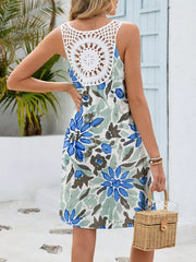 Botanical print mini dress with white crochet back detail and blue-green flowers.