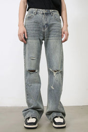 Distressed flare jeans in medium wash denim with raw-cut knee details and a relaxed fit.