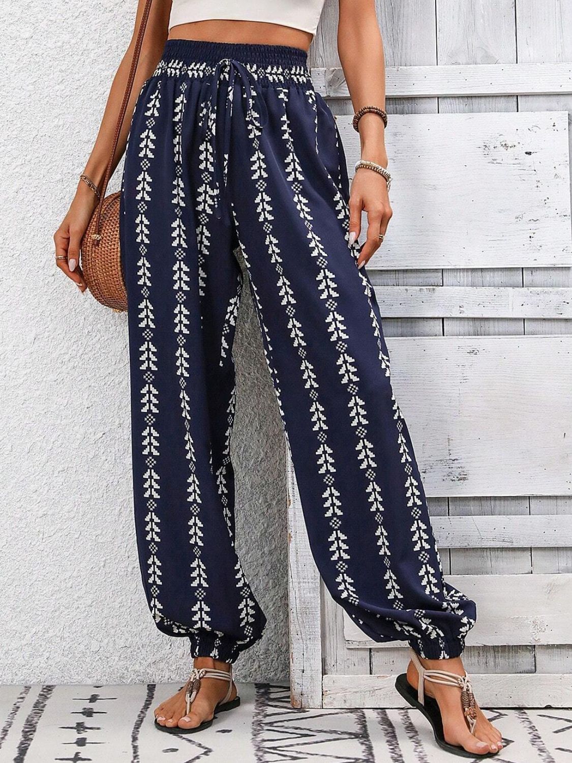 Dark Blue gathered ankle trousers with white leaf print, drawstring waist, and elastic cuffs.