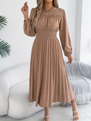 Ruffled smocked waist midi dress in khaki with long sleeves and a pleated skirt.