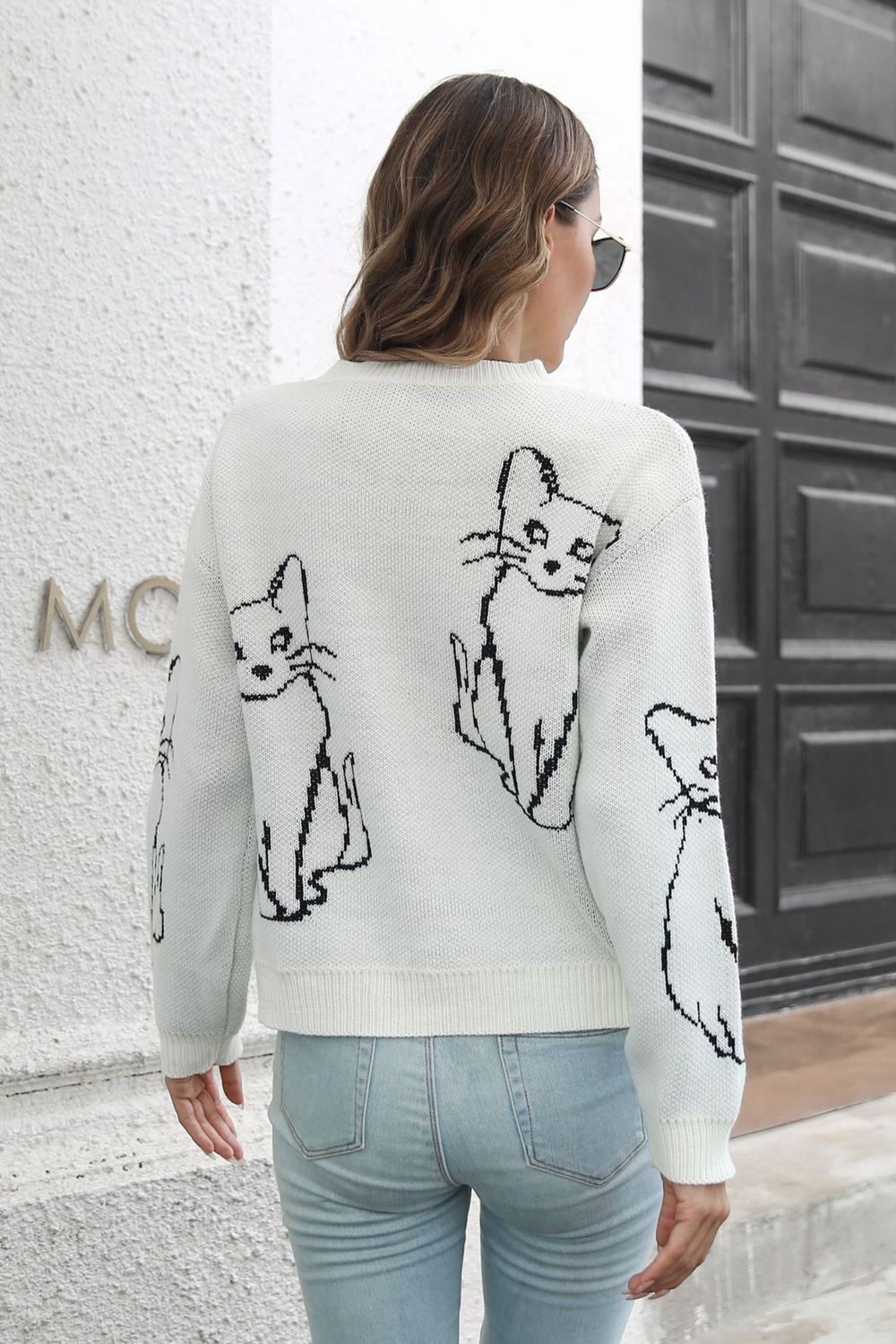 White acrylic sweater with black cat intarsia knit pattern, crew neck, long sleeves.