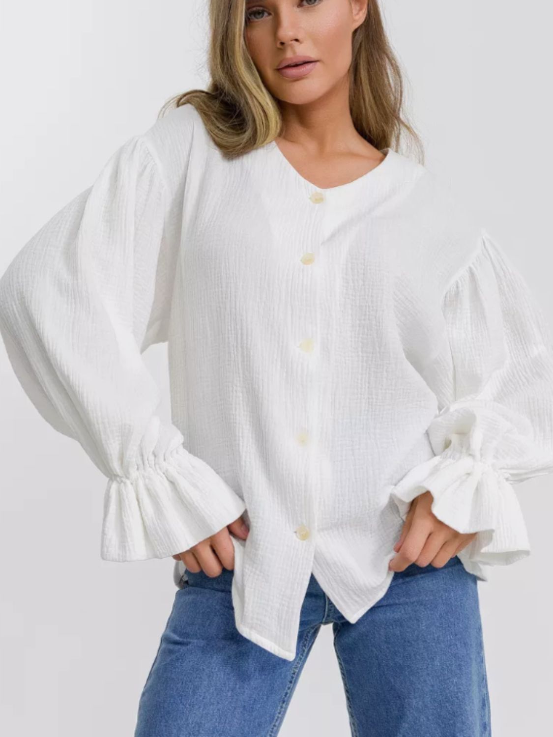 White textured puff sleeve blouse with ruffled cuffs and button front
