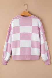 Checkerboard knit crewneck sweater in pink and white with balloon sleeves.