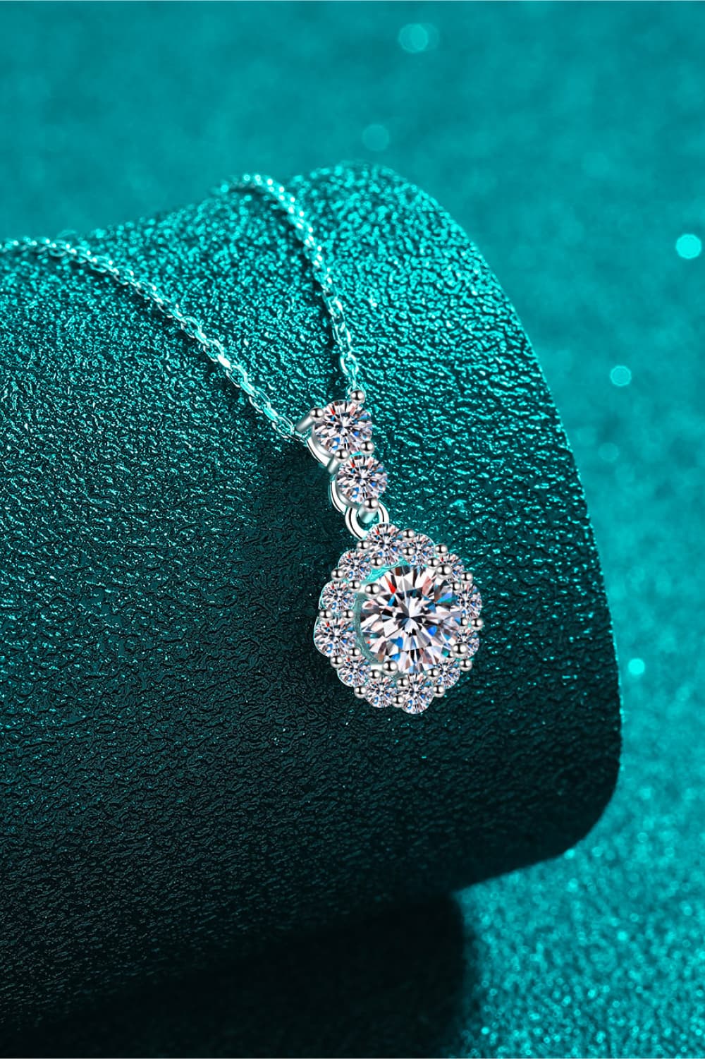 Halo moissanite pendant necklace in sterling silver with a delicate chain and sparkling halo design.