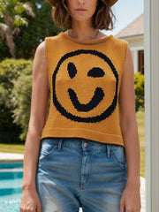 Mustard knit tank top with black smiley face graphic and crew neck.