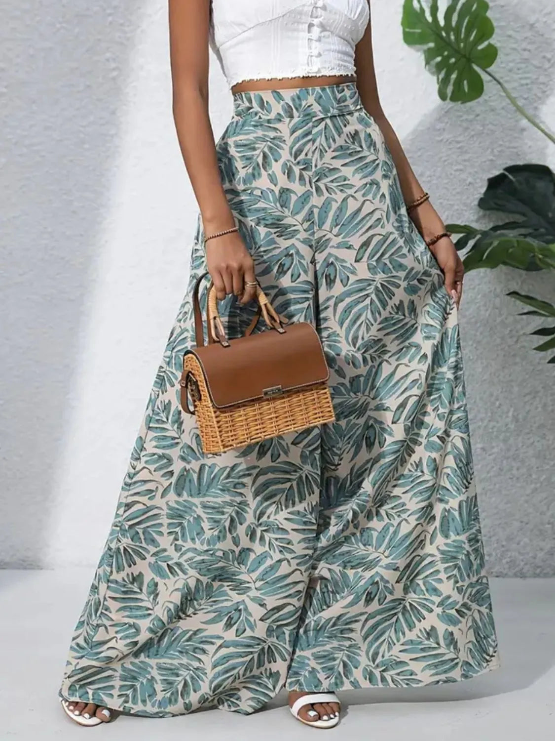 Palazzo trousers in green tropical leaf print, 100% polyester, with a wide leg cut.