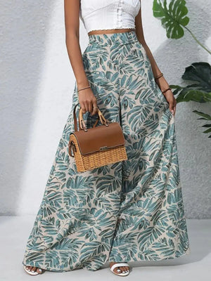 Palazzo trousers in green tropical leaf print, 100% polyester, with a wide leg cut.