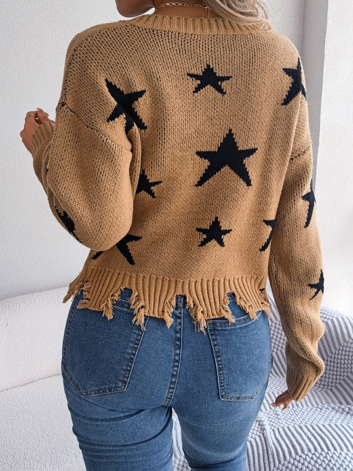 Camel knit sweater with black stars and distressed hem