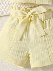 Light yellow ruffled ribbed toddler shorts with paperbag waist and tie detail.