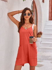 Layered V-neck romper in orange-red with oversized pockets and a white undershirt.