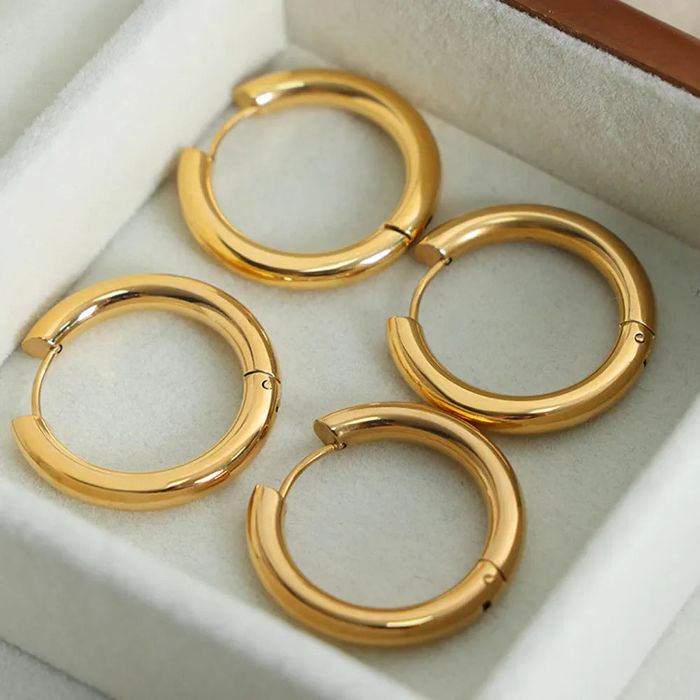 Gold hoop earrings with a sculpted, thick design, 18K gold-plated.