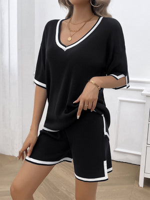Black knit loungewear set with white contrast trim on v-neck, sleeves, and shorts.