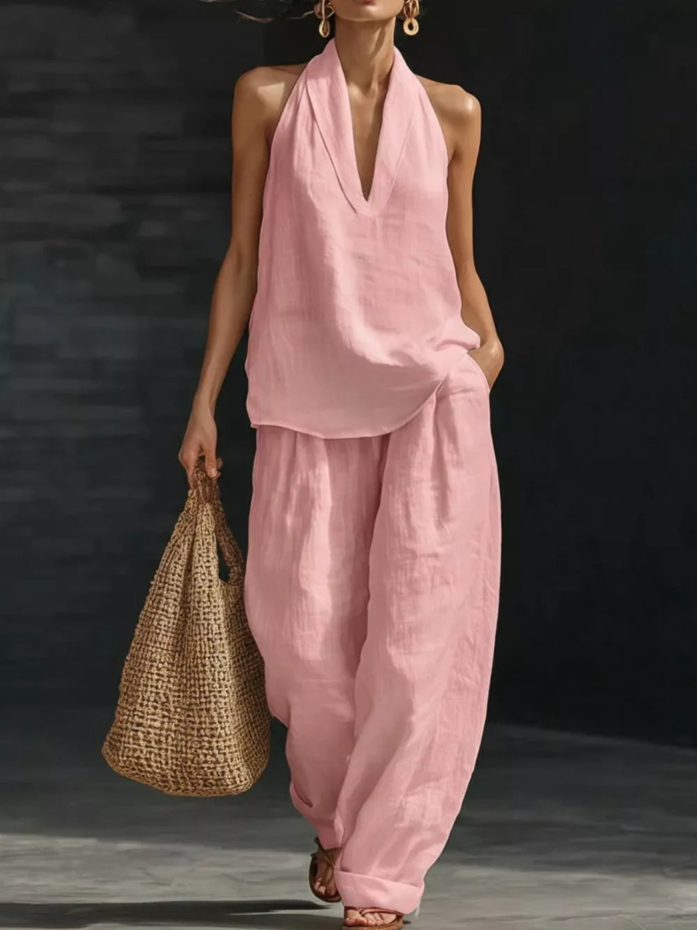 Pink halter neck top with deep V-neck and flowing wide-leg pants set.