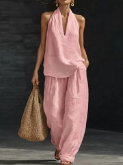 Pink halter neck top with deep V-neck and flowing wide-leg pants set.