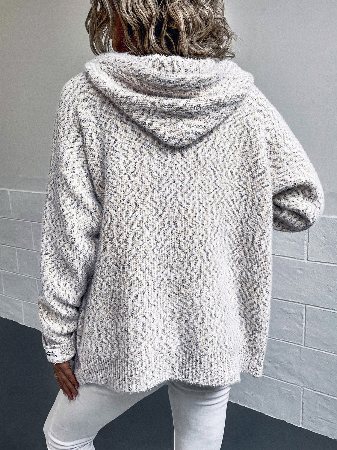 Textured knit hooded cardigan in a speckled white and grey pattern with a subtle herringbone texture.