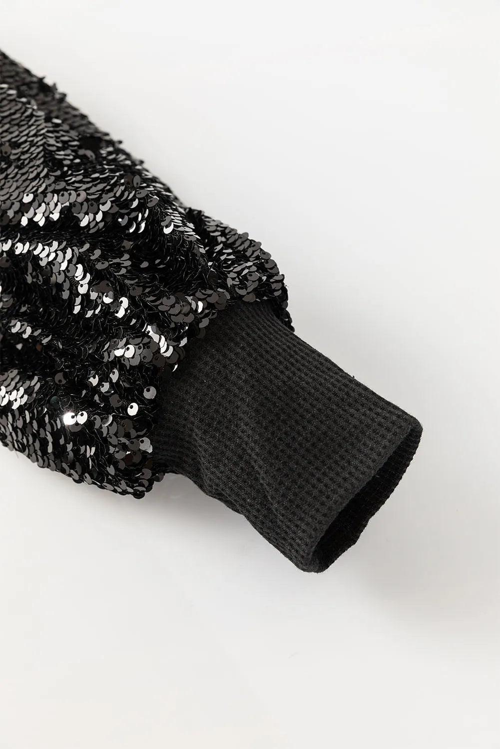Black sequin sleeve ribbed knit top with waffle knit cuff detail.