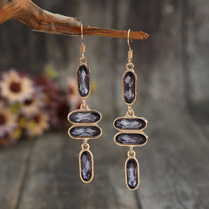 Geometric stone cascade earrings in gold with dark oval gems