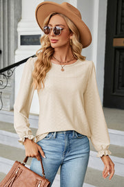Cream textured puff sleeve blouse with ruffled cuffs and crew neck.