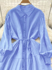 Blue textured tiered long sleeve midi dress with button-down front and tie waist.