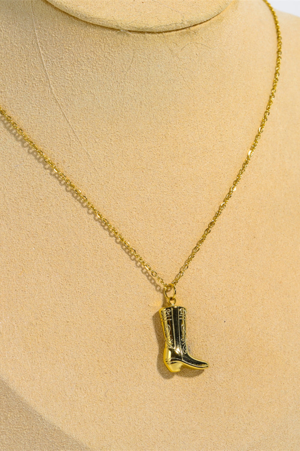 Gold cowboy boot charm necklace with intricate detailing on a delicate chain.