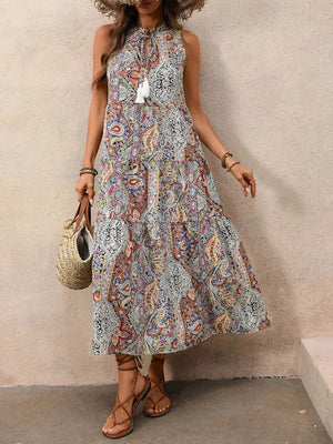 Paisley print midi dress with tie neck, decorative tassels, and tiered skirt.