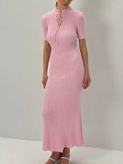 Blush pink knitted mermaid dress with tie neckline and short sleeves.