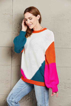 Colorblock knit sweater with sculpted sleeves in white, teal, orange, and pink acrylic.