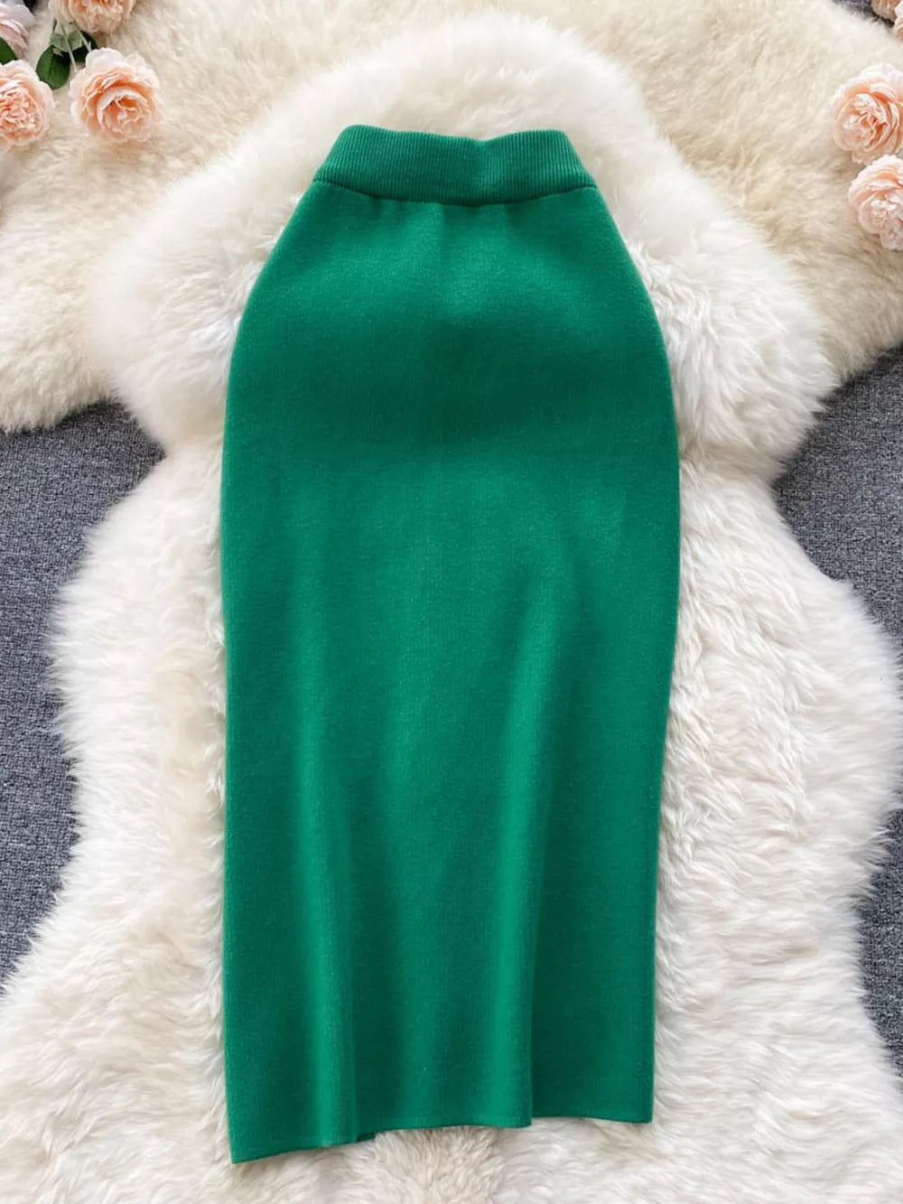 Green knit midi skirt with a ribbed waistband and a subtle side split.