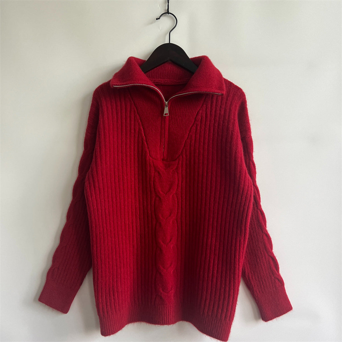 Red cable knit zip-neck sweater with ribbed texture and braided detail.