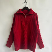 Red cable knit zip-neck sweater with ribbed texture and braided detail.