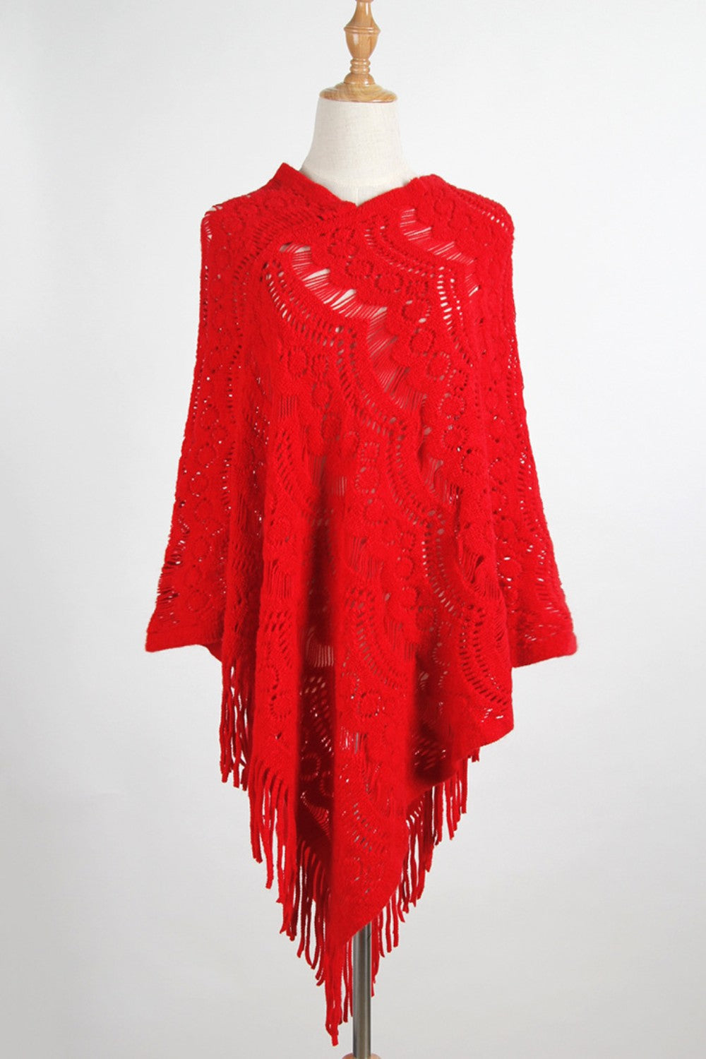 Red crochet poncho with intricate openwork pattern and fringe detail.
